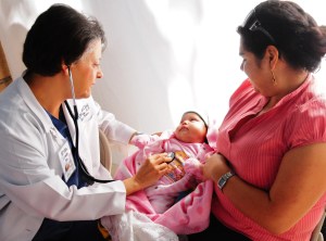 Dr. Aletha examining an infant on a volunteer trip