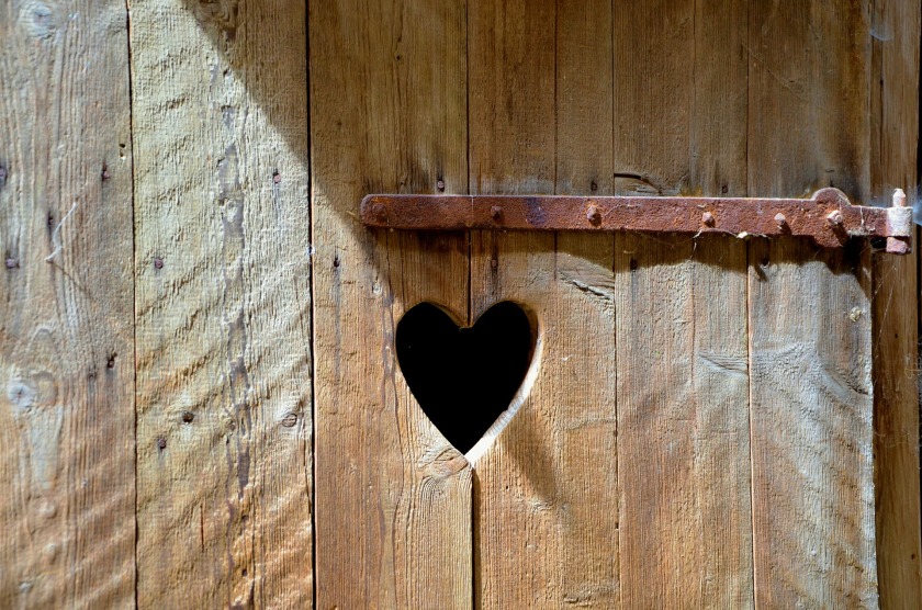 a wooden door with a heart shaped hold
