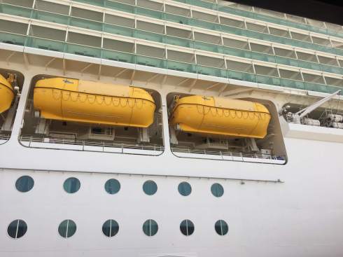 the side of a ship with 2 lifeboats