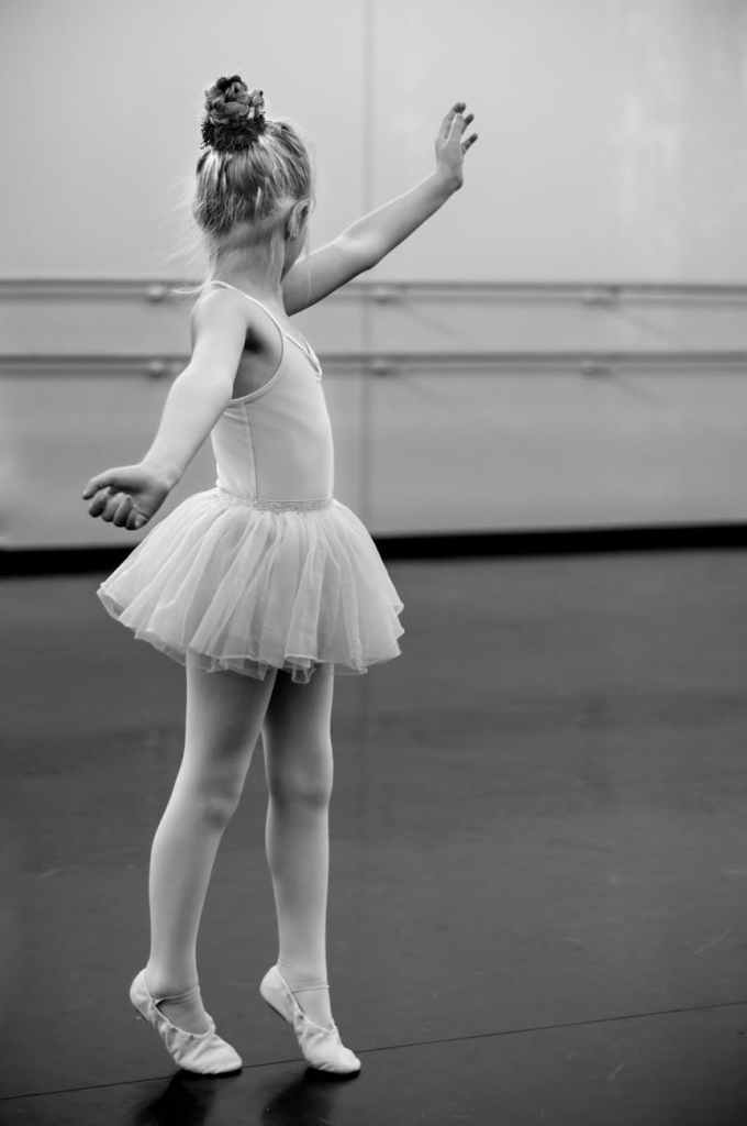 grayscale photography of young girl doing ballet
